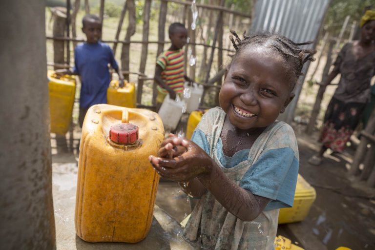 Meseret washes her hands with clean water at the Ropi-Sinta borehole installed by ChildFund in Siraro District, Ethiopia.